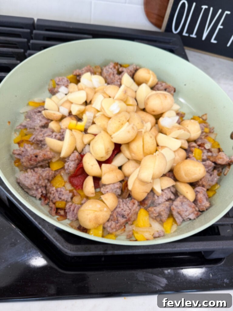 Adding quartered potatoes to the cooking skillet dinner