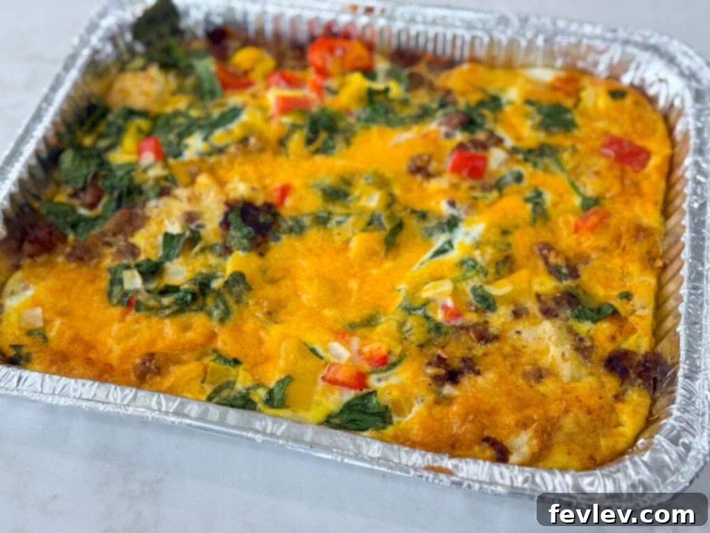 Effortless Breakfast Meal Prep 7 A hearty Sausage, Hash Brown, and Egg Casserole baking in a tin foil casserole dish.