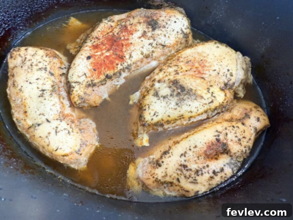 Effortless Slow Cooker Shredded Chicken 5 Cooked seasoned chicken in a slow cooker before shredding