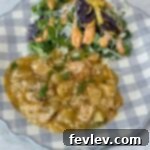 chicken and potatoes on a blue and white plate with salad