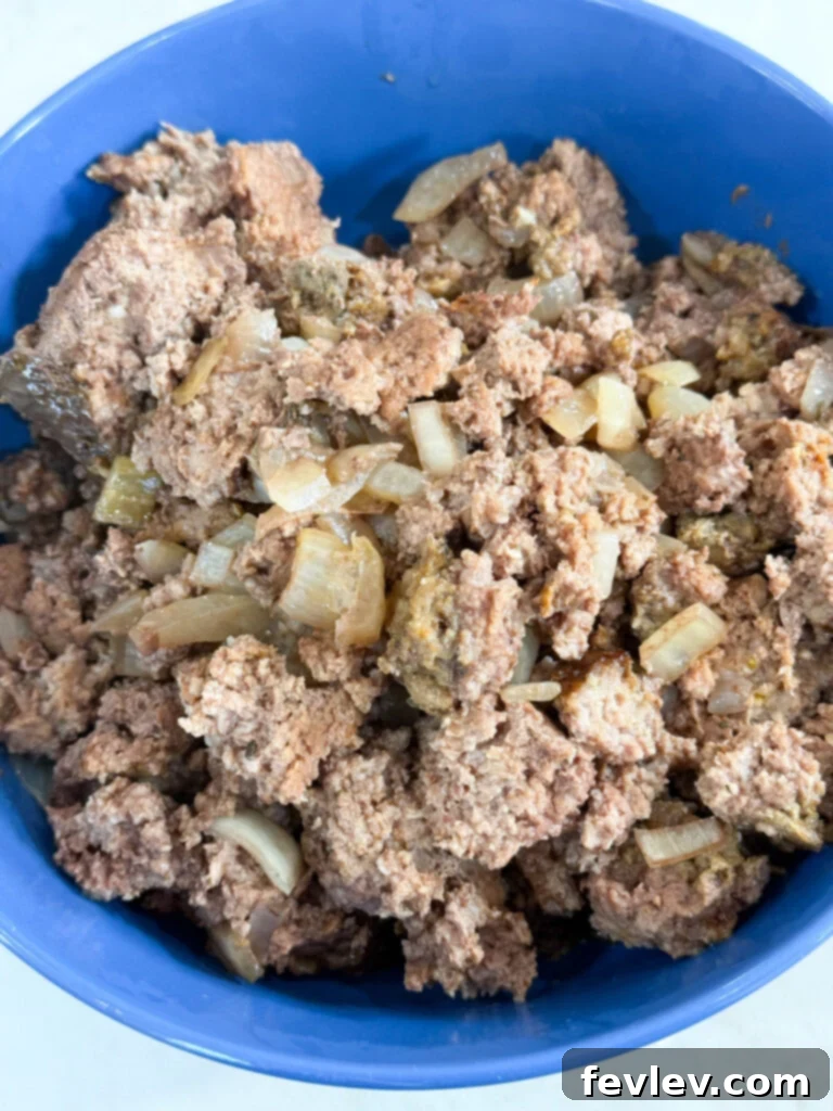 Cooked ground beef and onions in a blue bowl, ready to serve or meal prep.