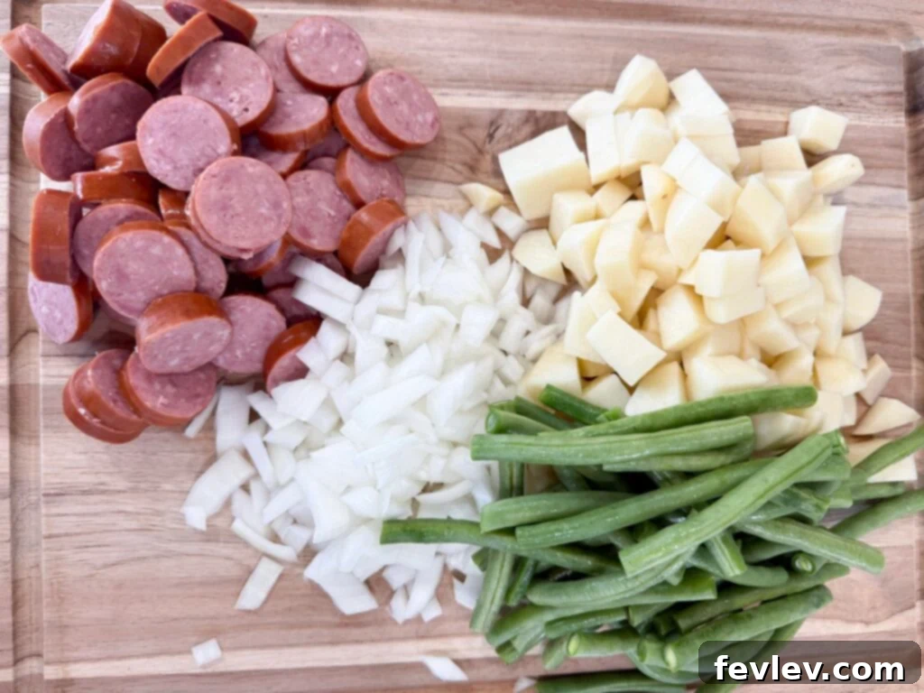 Hearty Slow Cooker Kielbasa with Potatoes and Green Beans 5 Chopped sausage, diced onions and potatoes, and green beans on a cutting board, ready for the slow cooker.