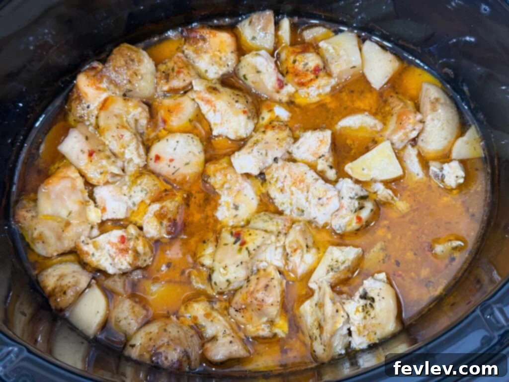 Cooked chicken in a rich garlic parmesan sauce in the slow cooker