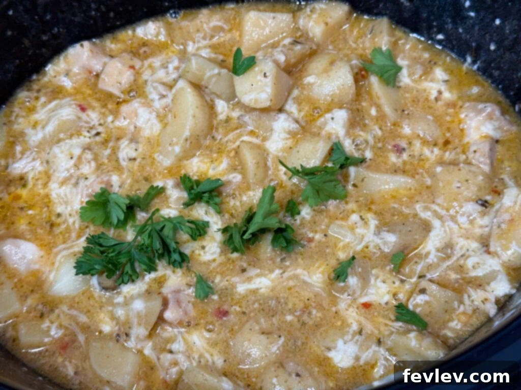 Creamy parmesan sauce with cooked chicken and fresh parsley, ready to serve