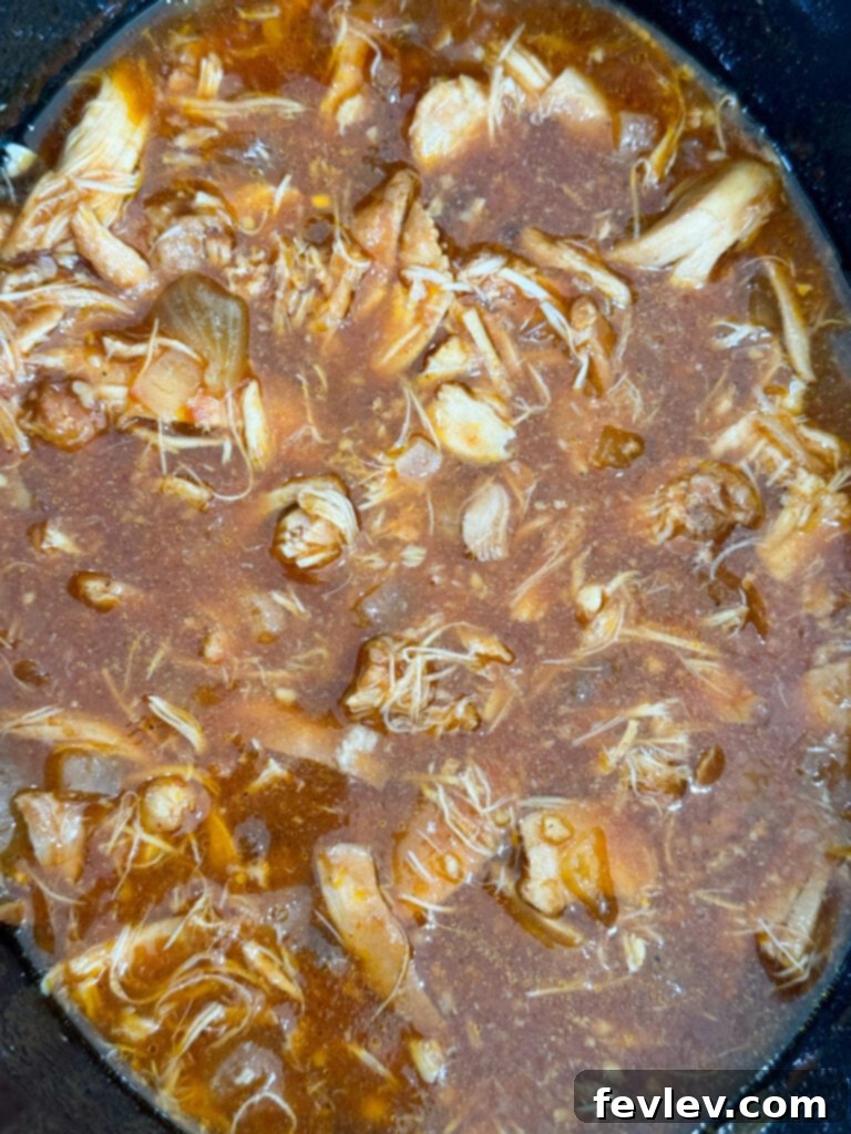 Cooked chicken in Hawaiian sauce, ready to be shredded for sandwiches
