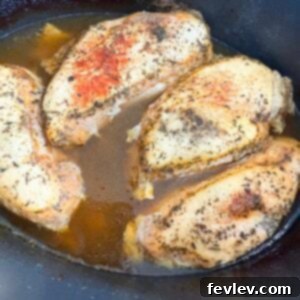 Cooked seasoned chicken in a slow cooker, shredded for versatility