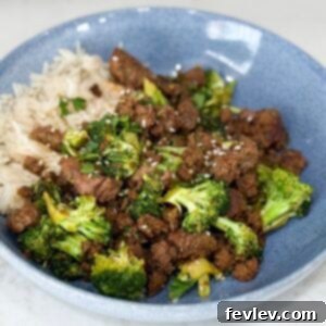 A vibrant Sweet & Spicy Turkey and Broccoli Bowl, expertly cooked and served in a striking blue bowl on a pristine white counter, ready to be savored as a healthy and flavorful meal.