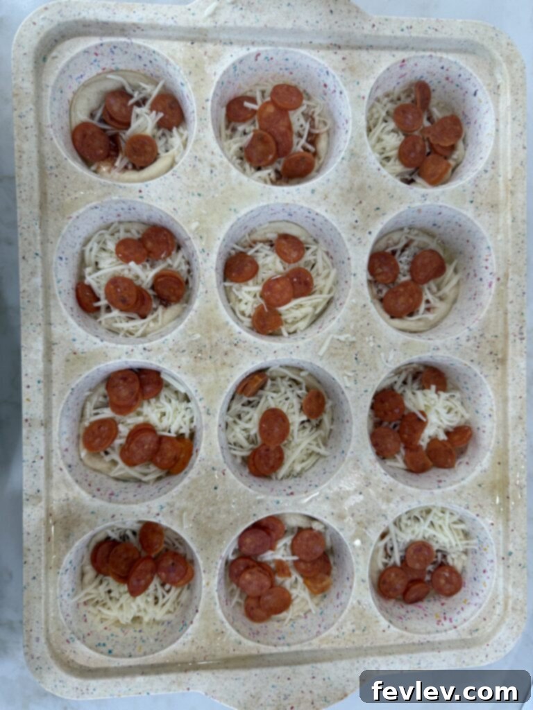 Quick Pizza Bites 2 Easy Pizza Cups arranged in a muffin tin, ready to bake.