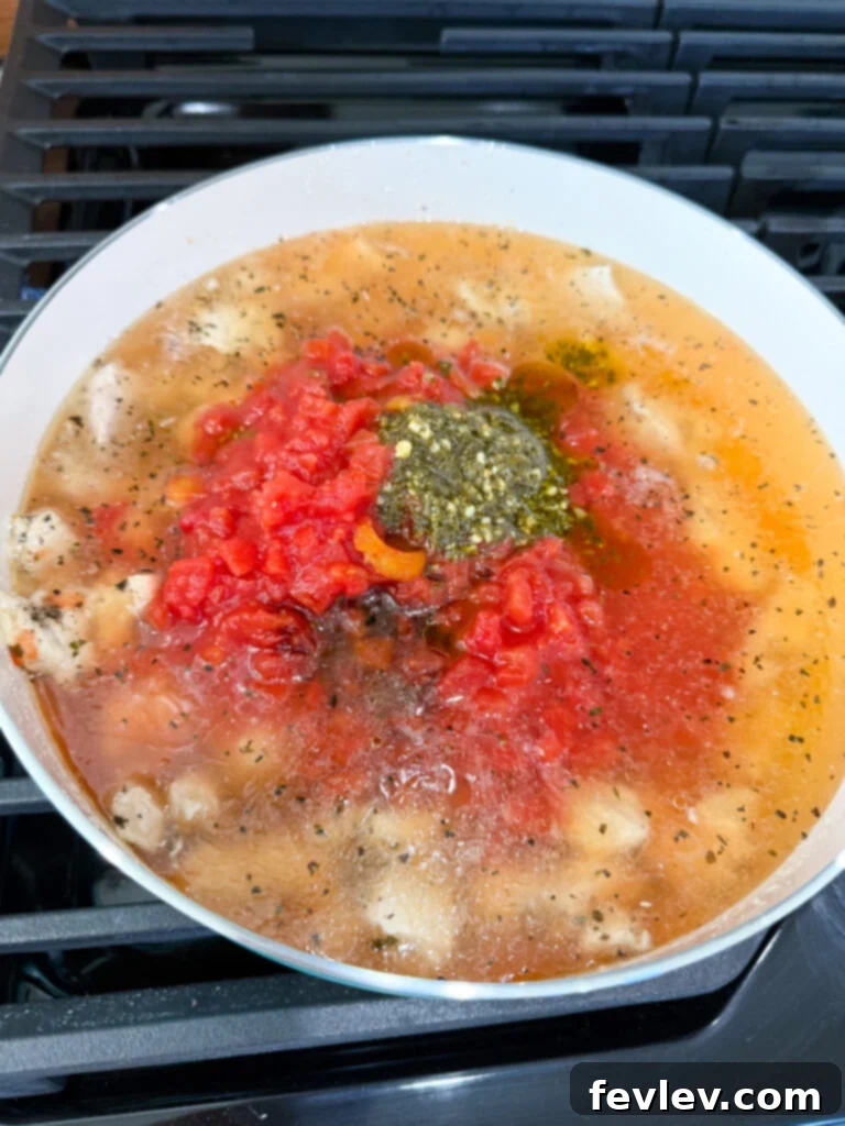 Step 4: Simmering the chicken and vegetable mixture with seasonings, covered, to deepen flavors.