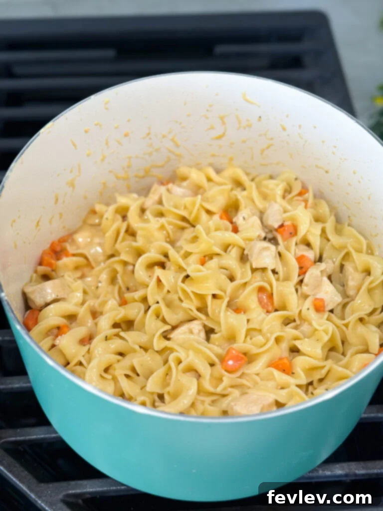 Step 6: Stirring heavy cream into the chicken mixture, then adding cooked egg noodles and tossing to coat.