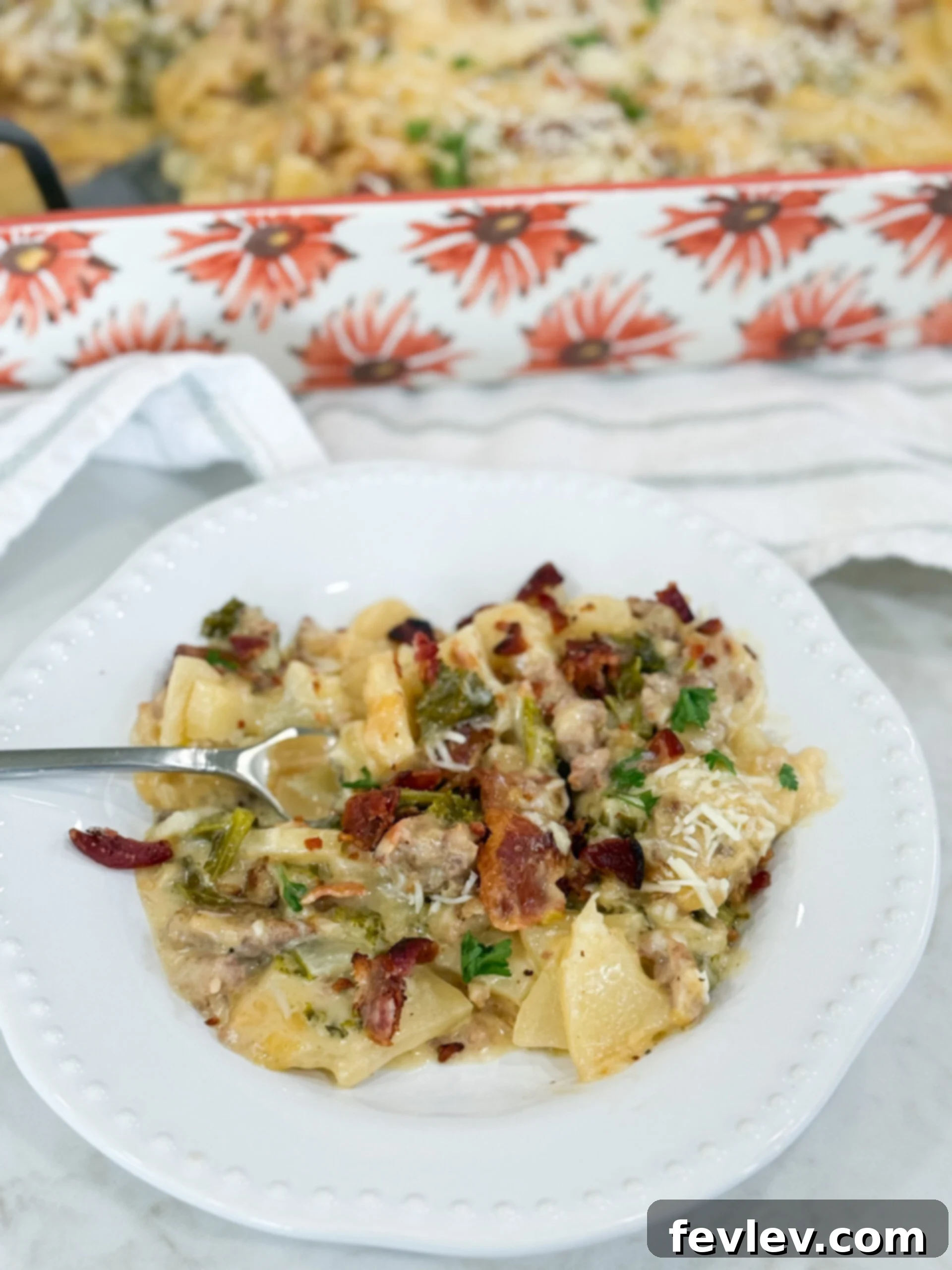 Creamy Tuscan Sausage Potato Kale Casserole 2 Serving of Zuppa Toscana Casserole plated with layers of potato, kale, sausage, bacon, and creamy sauce.