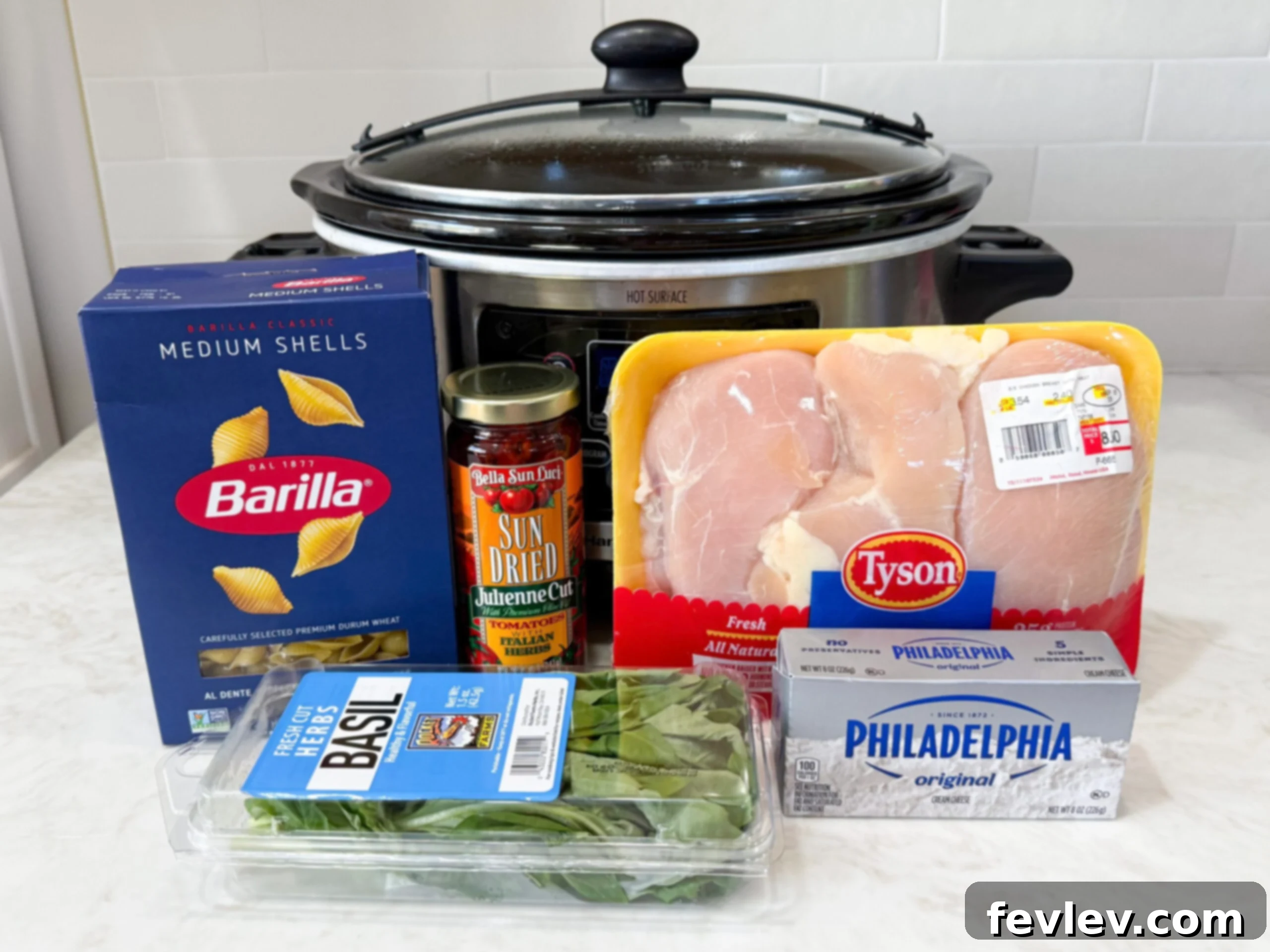 Irresistible Slow Cooker Marry Me Chicken Soup 3 All the fresh ingredients for Slow Cooker Marry Me Chicken Soup, including chicken, sun-dried tomatoes, pasta, spinach, and cheeses, neatly arranged on a kitchen counter.