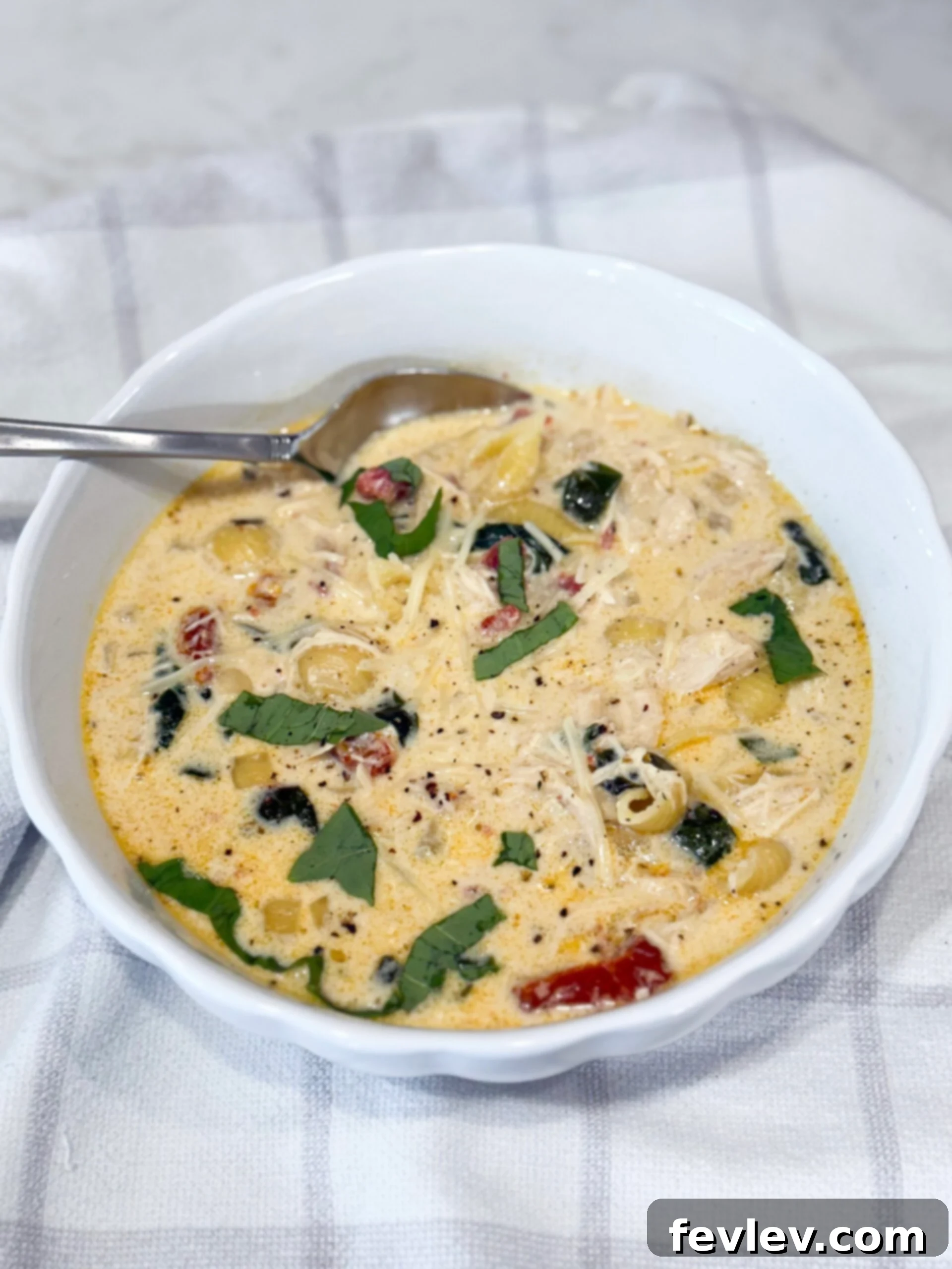 Irresistible Slow Cooker Marry Me Chicken Soup 8 A bowl of creamy Marry Me Chicken Soup, garnished with fresh Parmesan and basil, ready to serve.