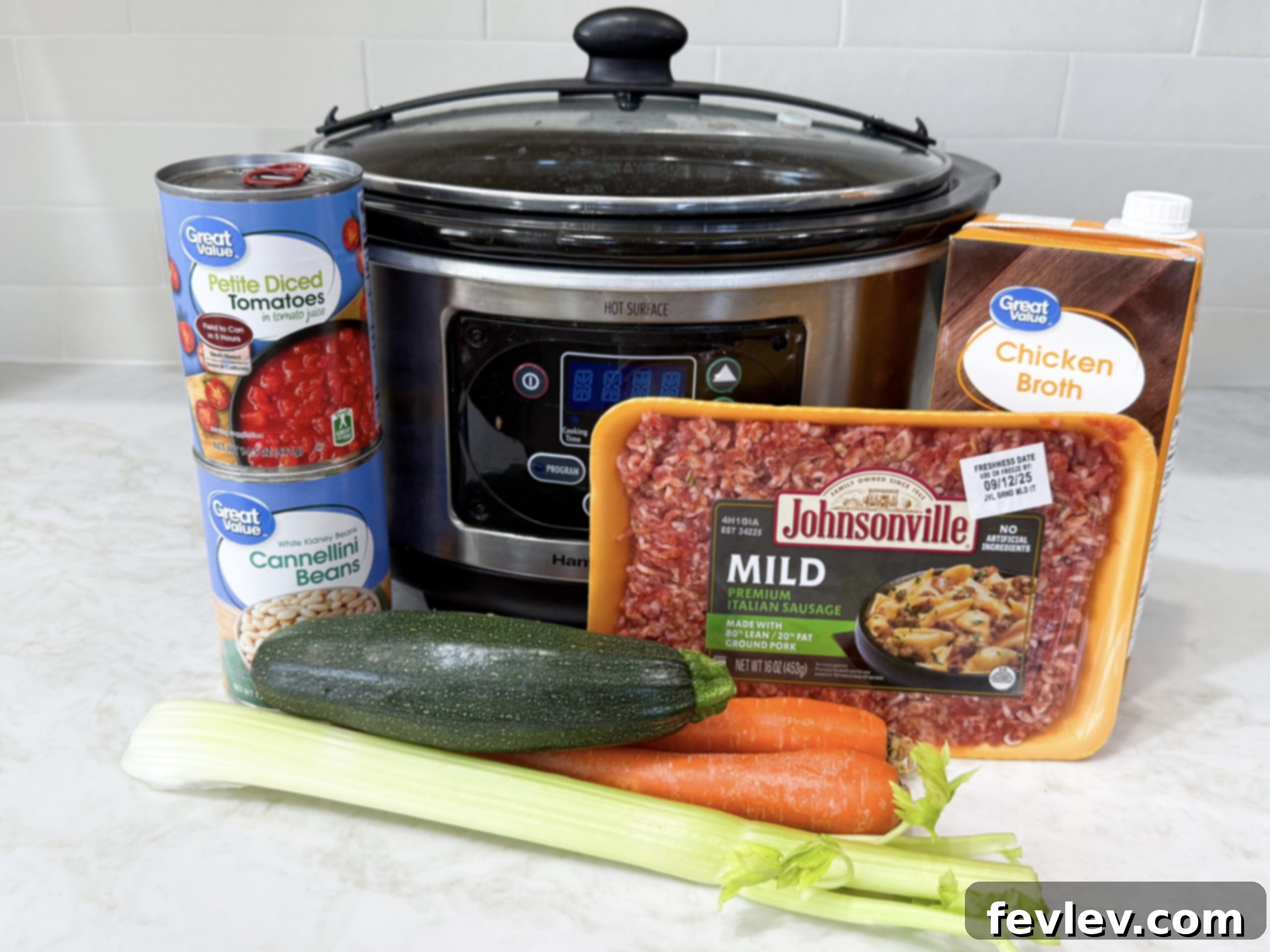 Tuscan Slow Cooker Sausage and Vegetable Soup 3 A beautiful flat lay of all the fresh and canned ingredients required for Italian Vegetable and Sausage Soup laid out on a clean kitchen counter, including raw Italian sausage, diced onion, sliced carrots, celery, zucchini, canned diced tomatoes, cannellini beans, and various herbs and spices.