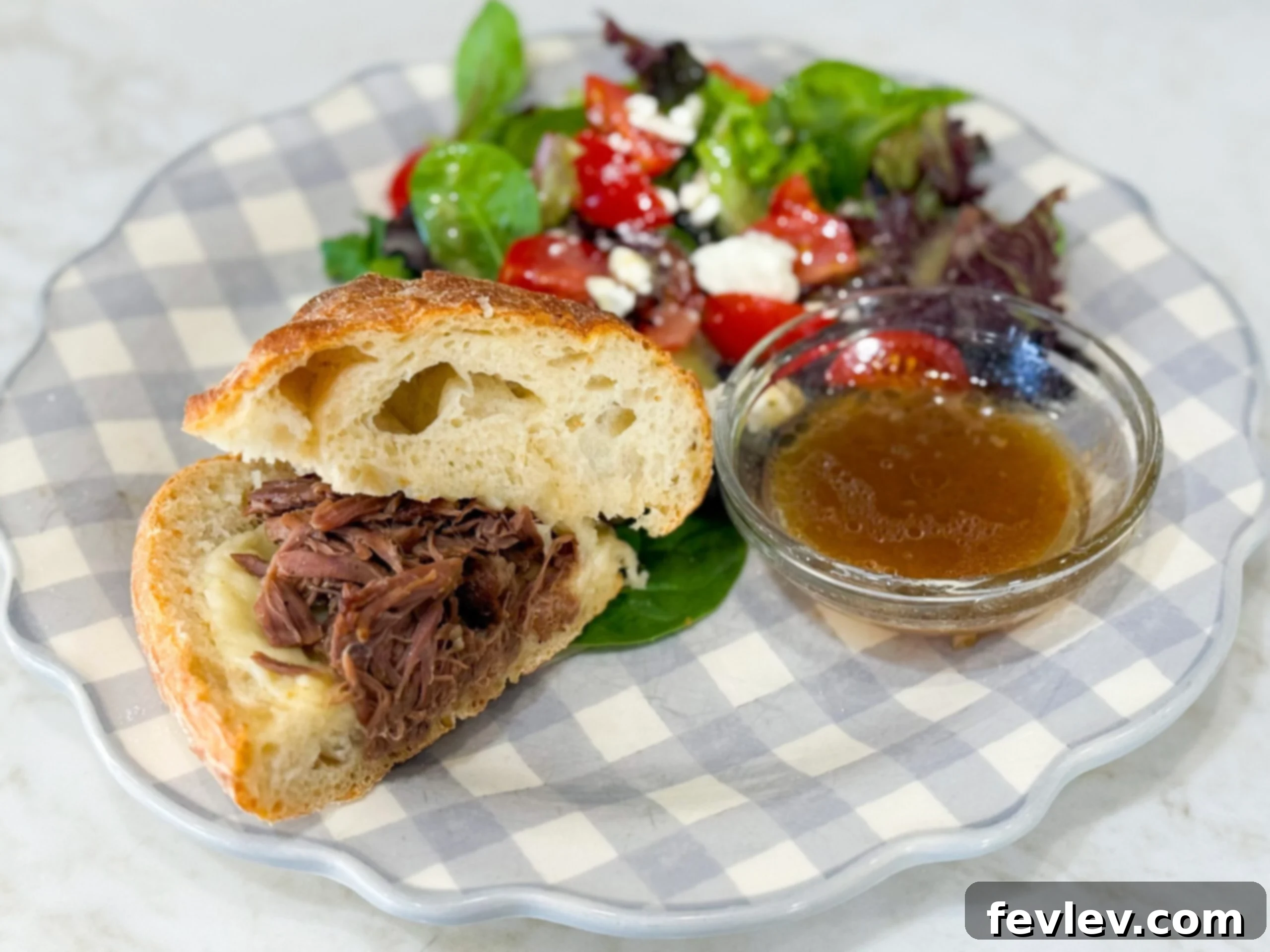 Close-up of savory pulled beef sandwiches with provolone cheese, served on soft buns, indicating a comforting and easy meal.
