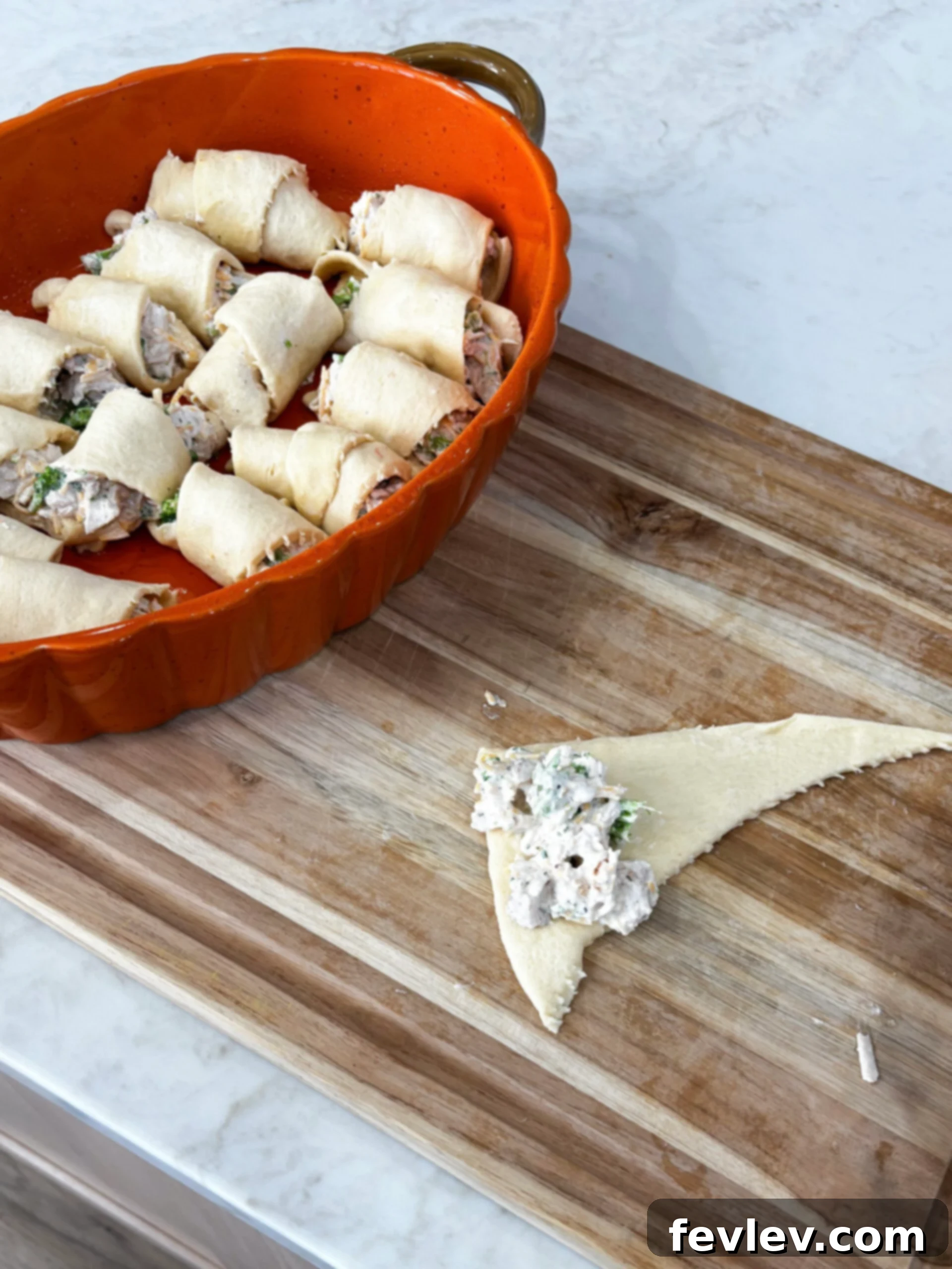 Rolling chicken mixture into crescent dough triangles