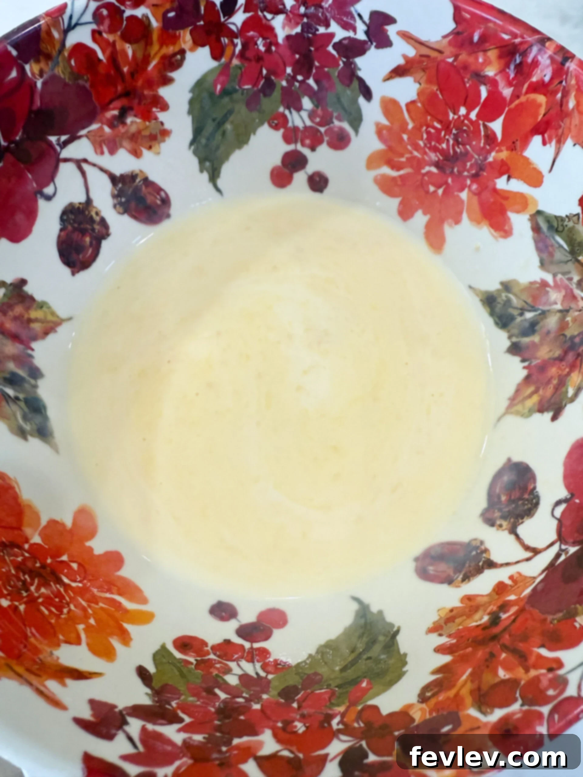 Chicken soup and milk wisked together in a bowl