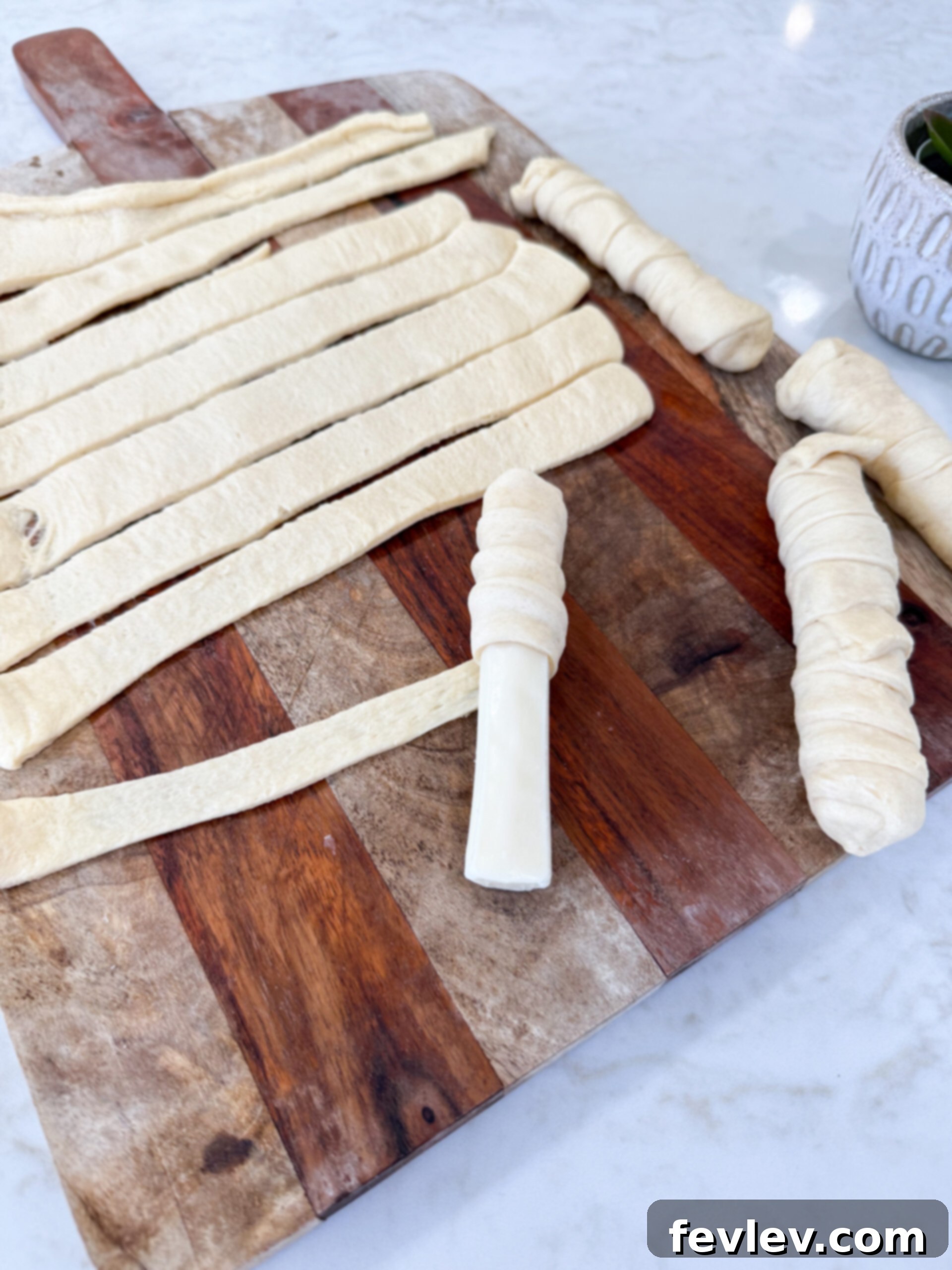 Unrolled crescent dough sheet cut into 9 even strips.