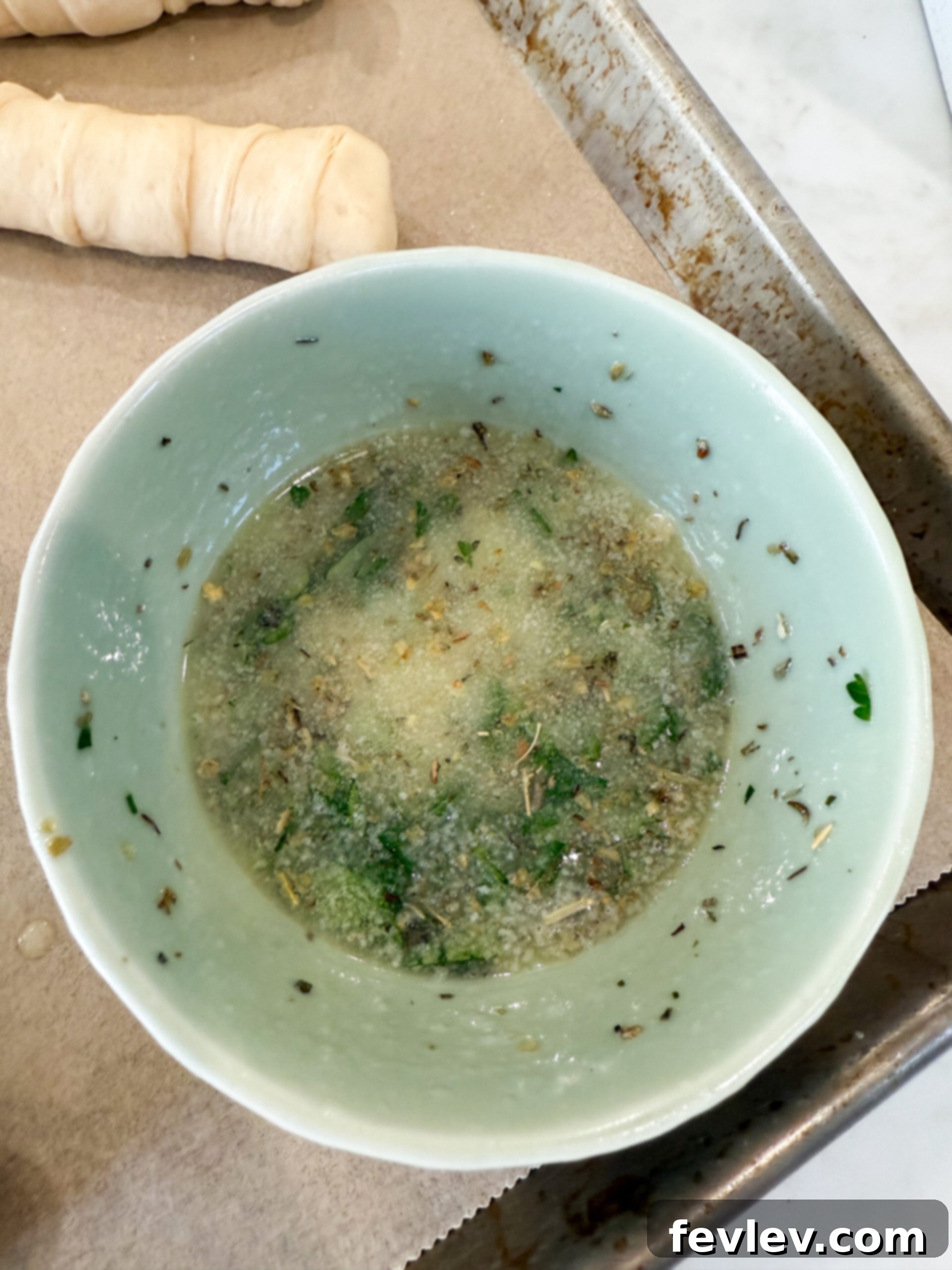 Melted butter, fresh parsley, minced garlic, and Italian seasoning combined in a small bowl.