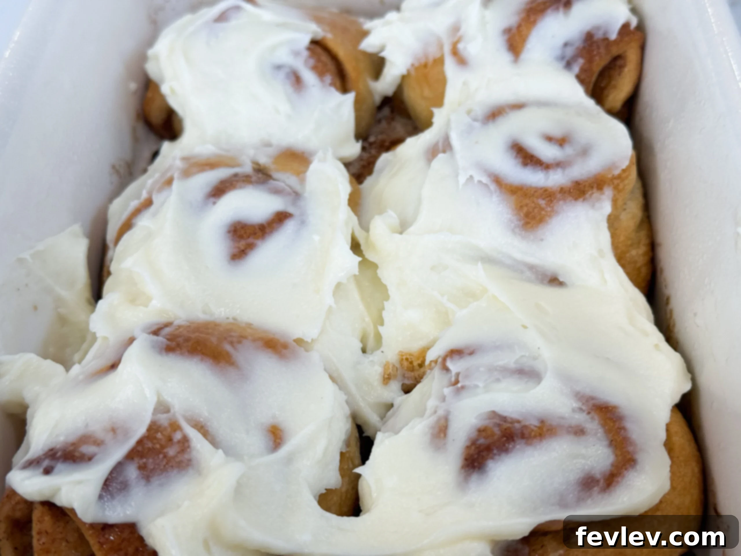 Gooey crescent roll cinnamon rolls baked to golden perfection and generously topped with a creamy white cream cheese frosting.