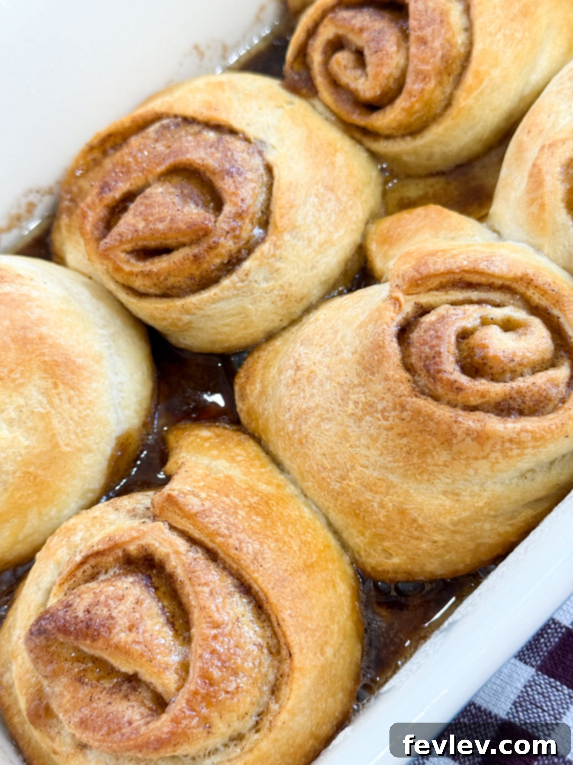 Golden brown crescent roll cinnamon rolls freshly baked in a pan.