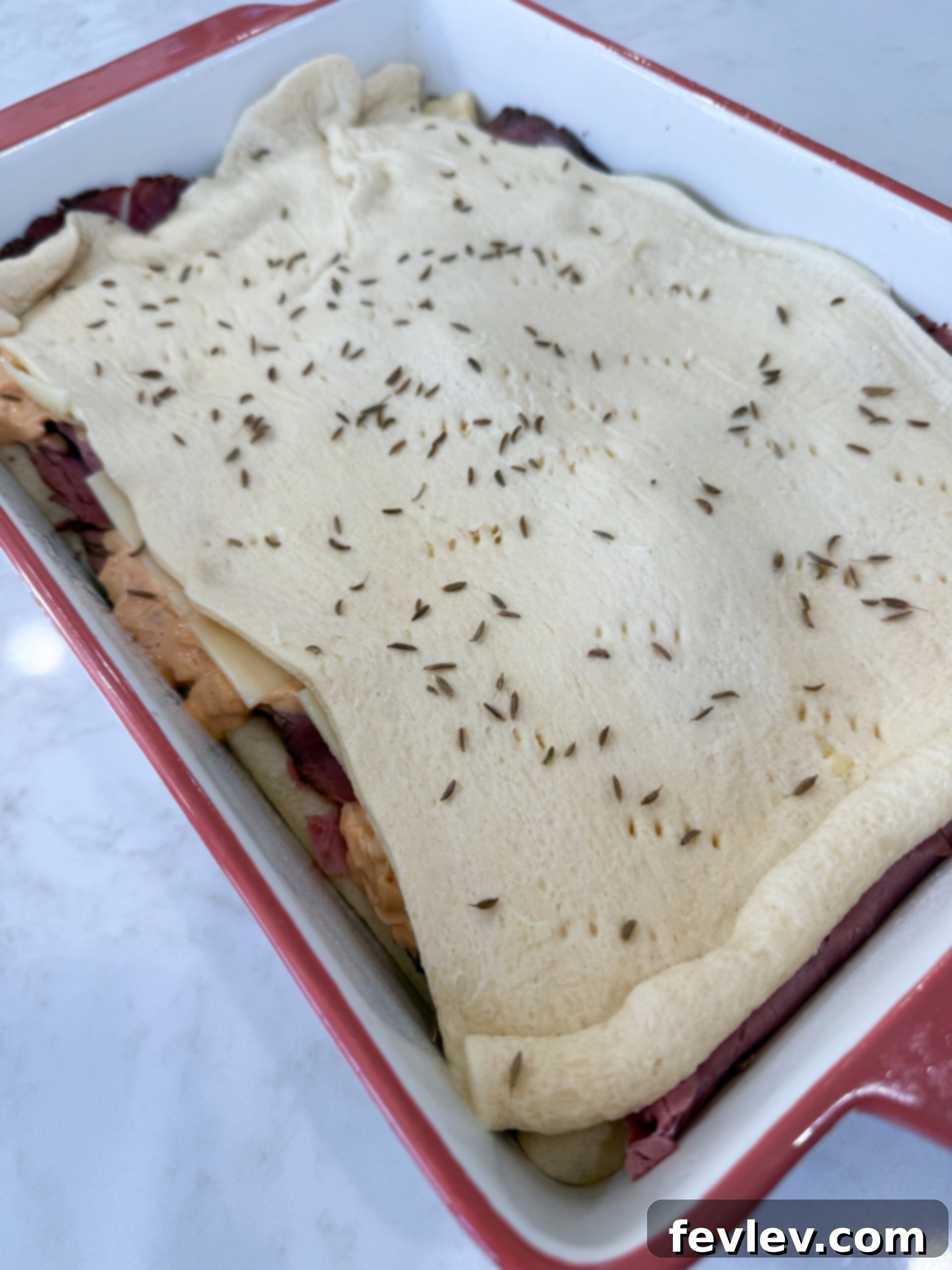 Pastrami Crescent Melt 9 Second crescent dough sheet placed on top, with edges pressed.