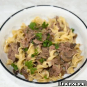 Slow cooker beef stroganoff served with noodles and parsley