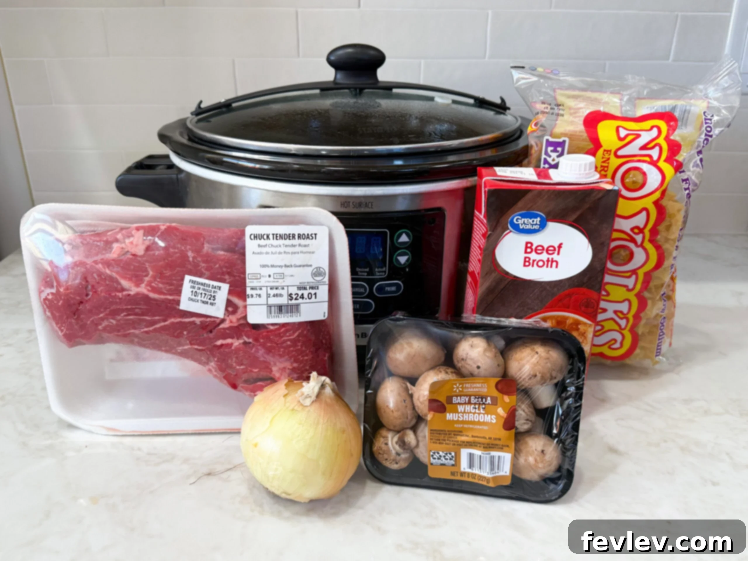 Tender & Creamy Slow Cooker Beef Stroganoff 5 Ingredients for slow cooker beef stroganoff laid out on a kitchen counter, including chuck roast, mushrooms, onions, and various liquids and seasonings