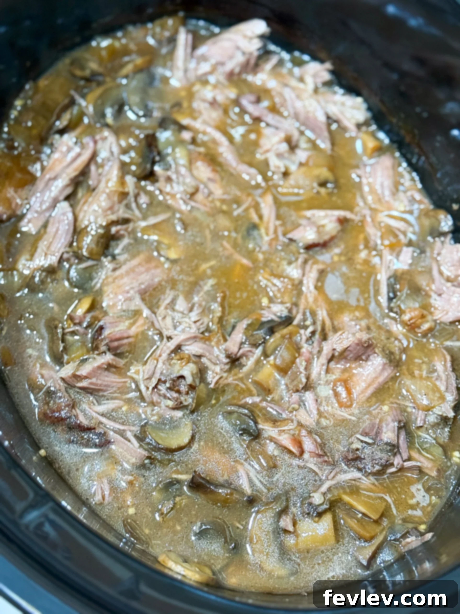 Tender & Creamy Slow Cooker Beef Stroganoff 9 Beef stroganoff simmering in the slow cooker, filled with tender beef, mushrooms, and a rich sauce