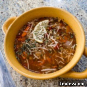 A steaming bowl of hearty and healthy lentil soup garnished with fresh herbs.