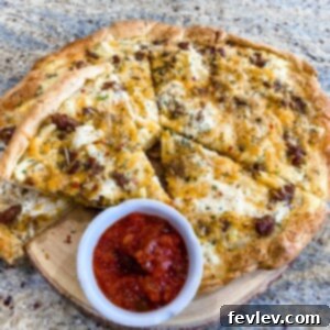 Delicious Breakfast Pizza made with flaky crescent roll dough, topped with eggs, sausage, hash browns, and cheese.