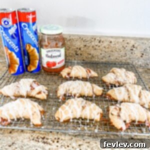 Golden, flaky jam-filled crescent rolls drizzled with a sweet vanilla glaze, ready to be enjoyed as a delightful breakfast or dessert.