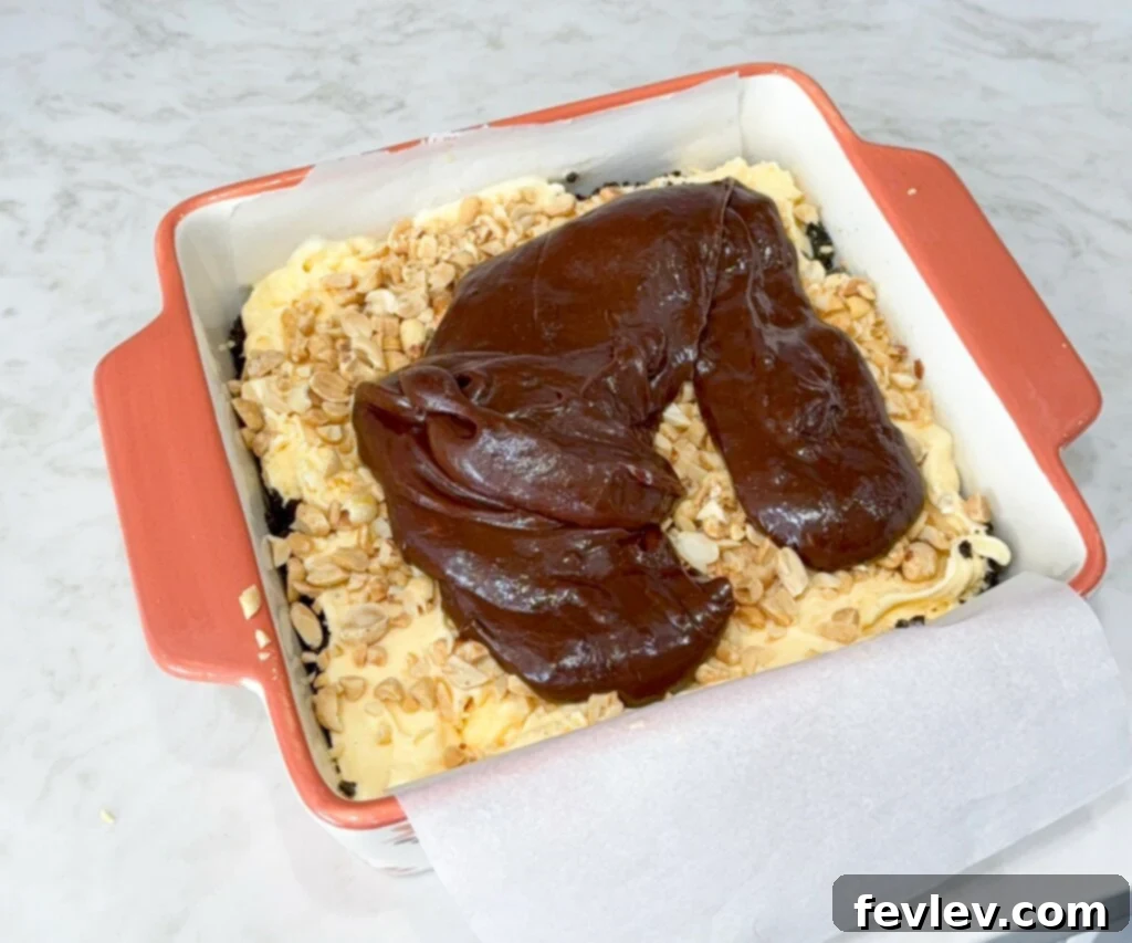 Drizzling chocolate fudge over peanuts