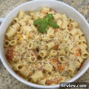 Delicious Baked Feta Pasta with roasted cherry tomatoes and fresh basil, a vibrant and creamy dish.
