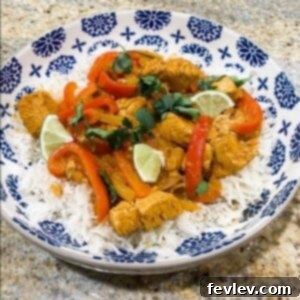 A vibrant bowl of creamy Coconut Curry with chicken and bell peppers, garnished with fresh cilantro and served with fluffy white rice.
