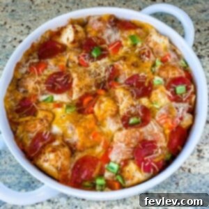Delicious golden brown Pizza Bubble Up in a baking dish, topped with melted cheese, pepperoni, and diced bell peppers.