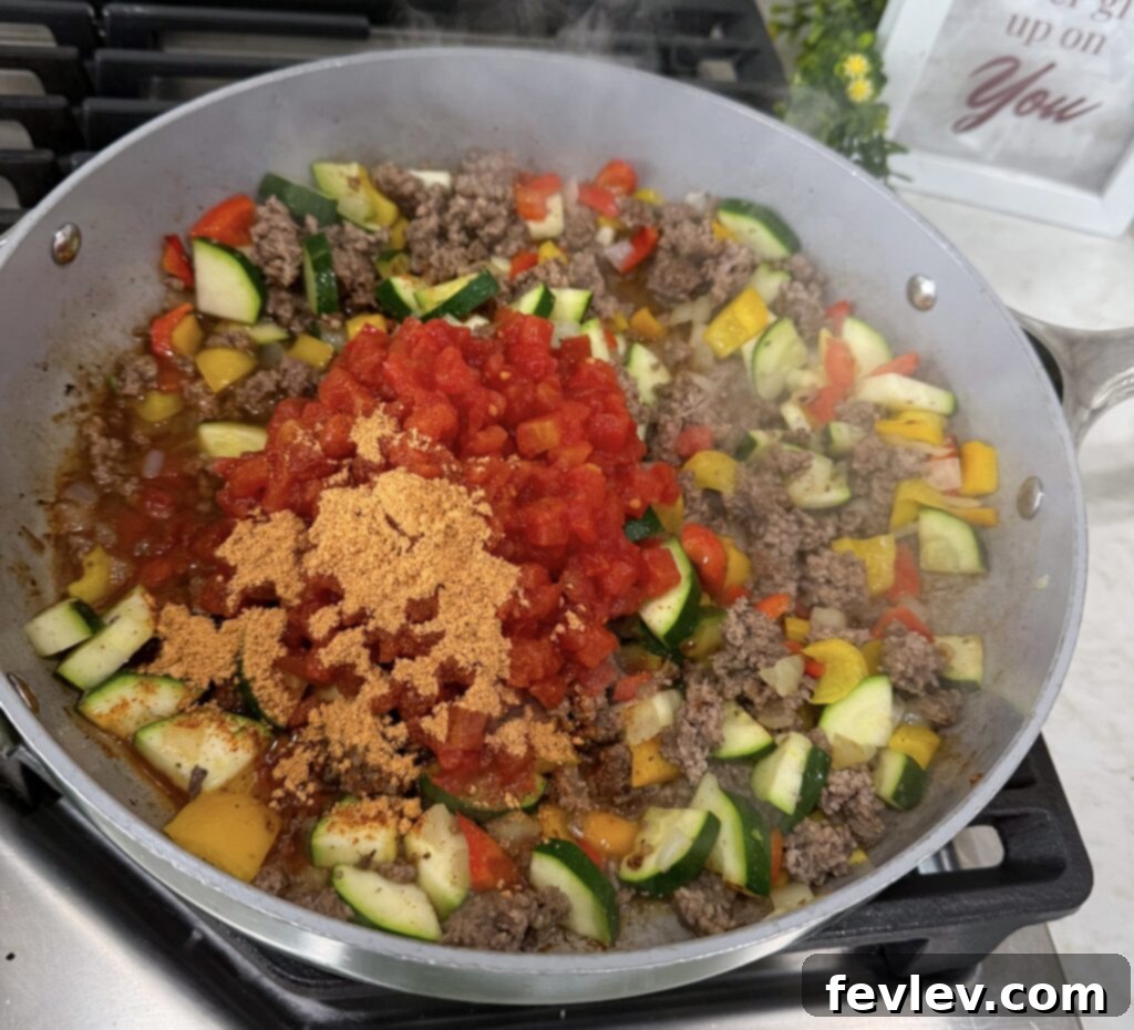 Quick Skillet Taco Dinner 4 Taco skillet mixture simmering with diced tomatoes and seasoning