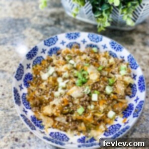 Delicious Egg Roll in a Bowl with ground turkey, cabbage, and carrots, garnished with sesame seeds and green onions.