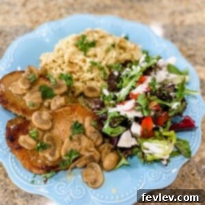 Deliciously seared pork chops covered in a rich mushroom gravy, ready to be served