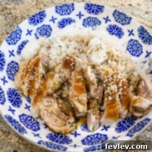 Close-up of golden brown Teriyaki Chicken thighs glazed with sticky sauce, garnished with sesame seeds and green onions, served with a side of white rice.