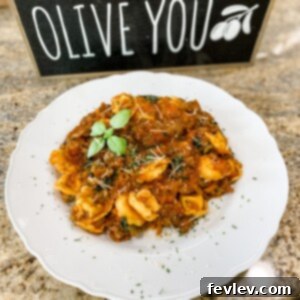 Delicious One Pot Sausage Tortellini in a large skillet, garnished with fresh parsley and parmesan cheese.