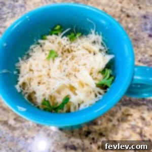 Creamy Microwave Alfredo Noodles in a mug with parsley garnish