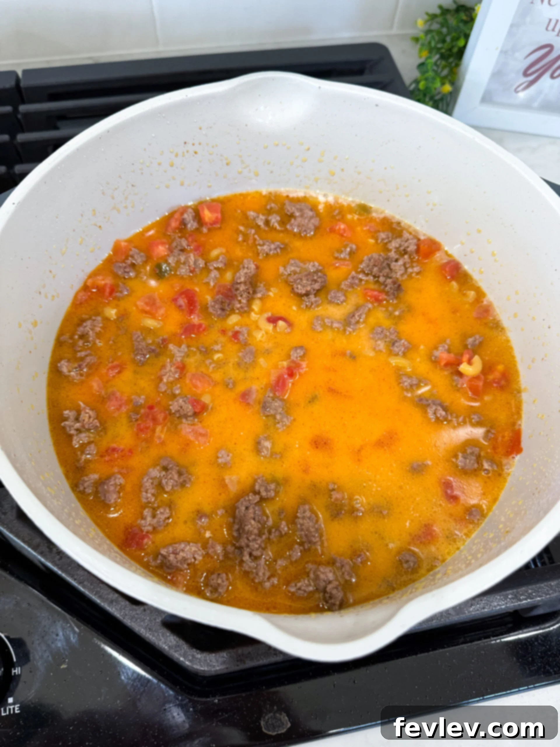 Stirring in the shredded cheddar and Monterey Jack cheeses into the hot taco pasta for a creamy finish.