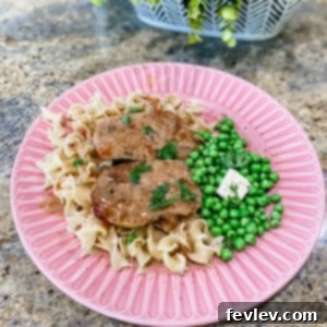 Rich and Creamy Pork Chops prepared in a slow cooker, served with a savory sauce