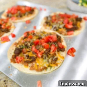 Delicious Taco Pizzas with ground beef, cheese, and fresh toppings. A perfect blend of Mexican and Italian flavors.