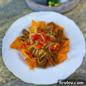 Delicious layered Dorito Pie with ground beef, beans, cheese, and tomatoes