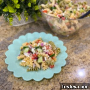 Vibrant Greek Pasta Salad with rotini pasta, fresh vegetables, and feta cheese.
