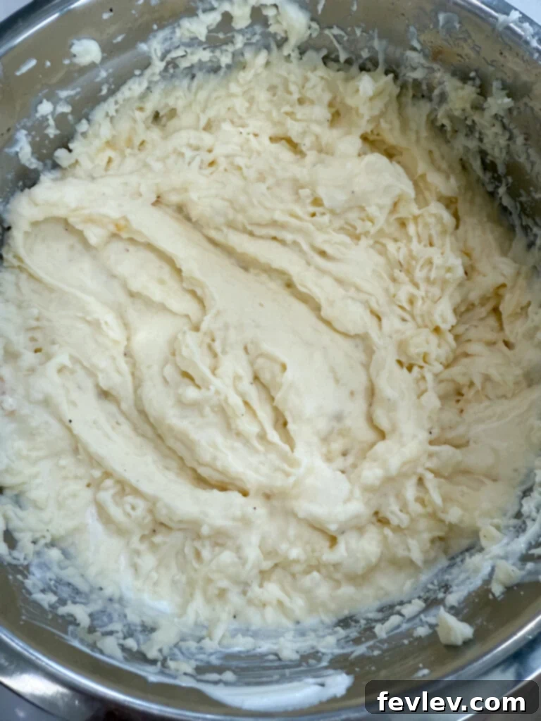 Double Delicious Potato Bake 5 Mashing the potato mixture to a creamy, smooth consistency using a potato masher