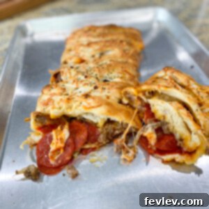 Delicious golden-brown Pizza Bread sliced and ready to serve, filled with melted cheese, pepperoni, and Italian sausage.