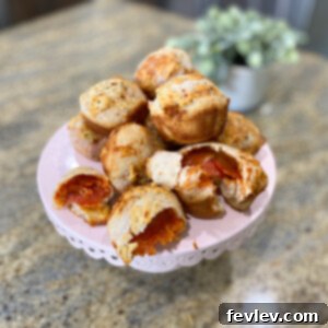 Delicious golden-brown pizza bombs with melted cheese and pepperoni, served with marinara sauce.